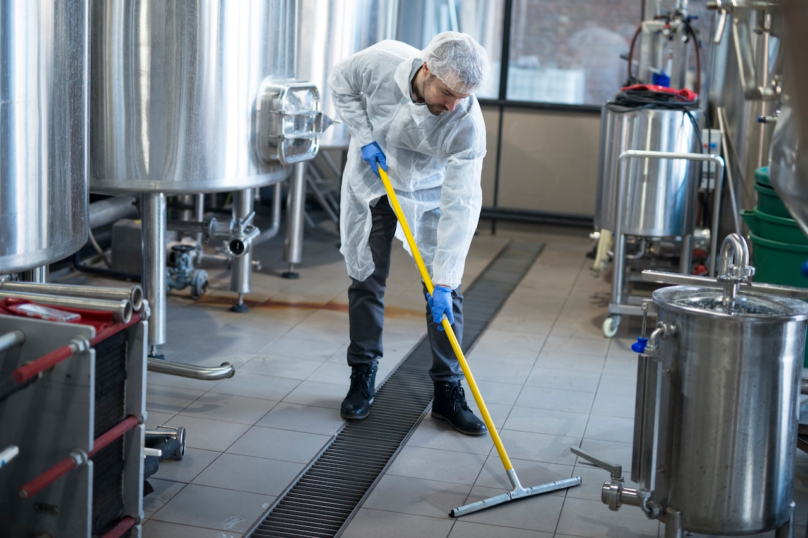 professional-cleaner-wearing-protection-uniform-cleaning-floor-production-plant-1.webp