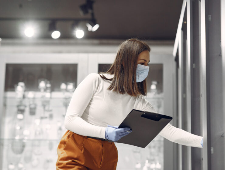 Woman examines various items of dishes. Beautiful woman shopping tableware in supermarket. Corona virus concept.