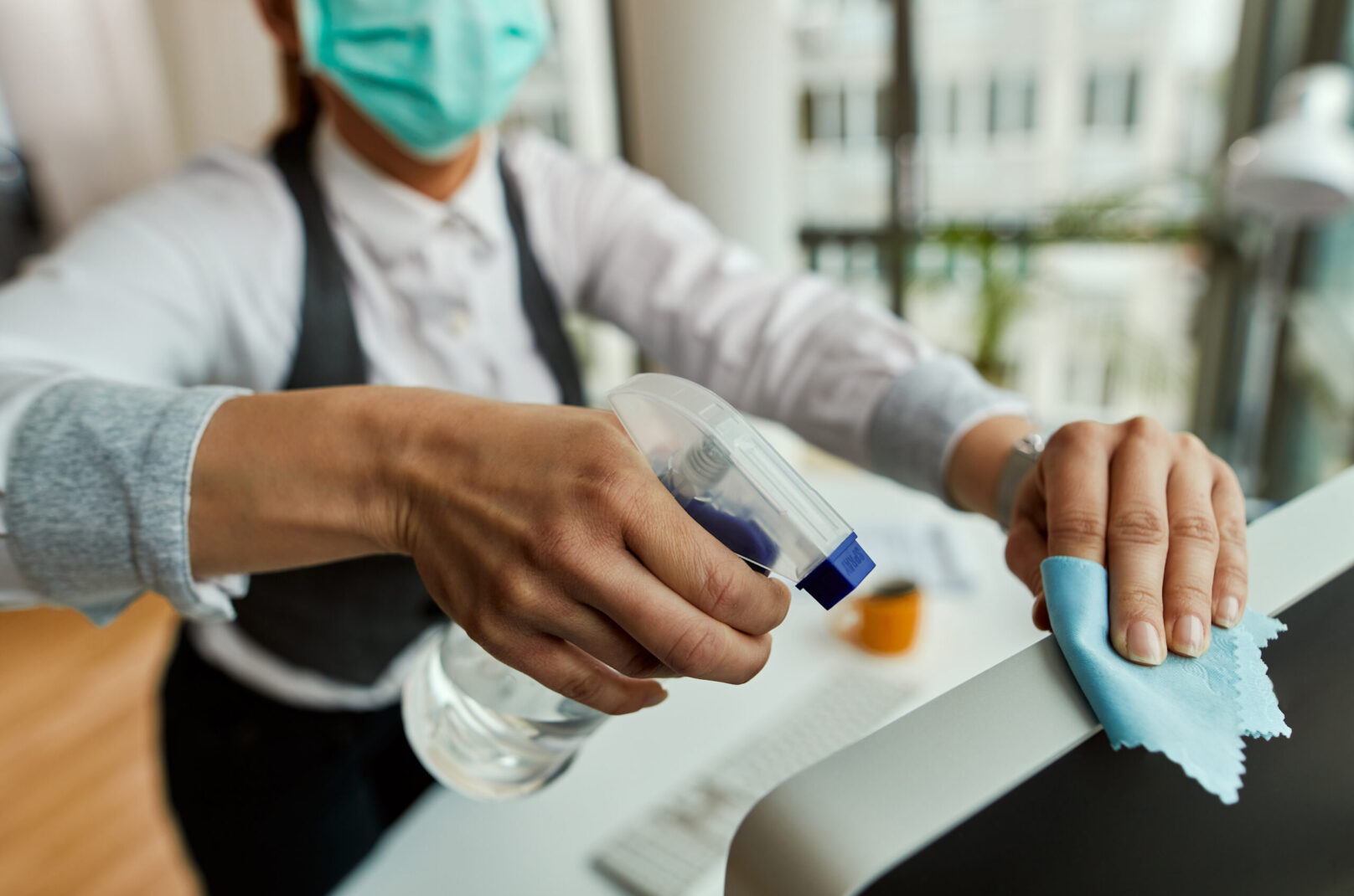 Close-up of businesswoman cleaning her computer while working in the office.