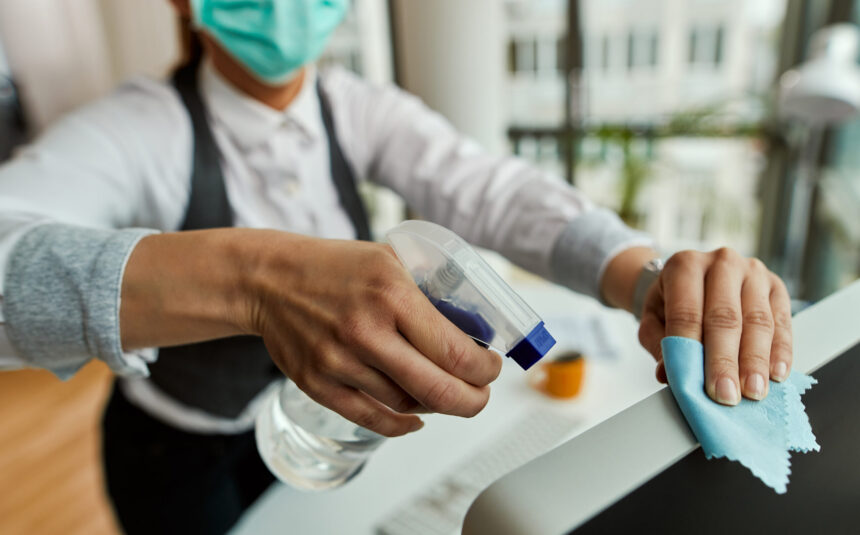 Close-up of businesswoman cleaning her computer while working in the office.