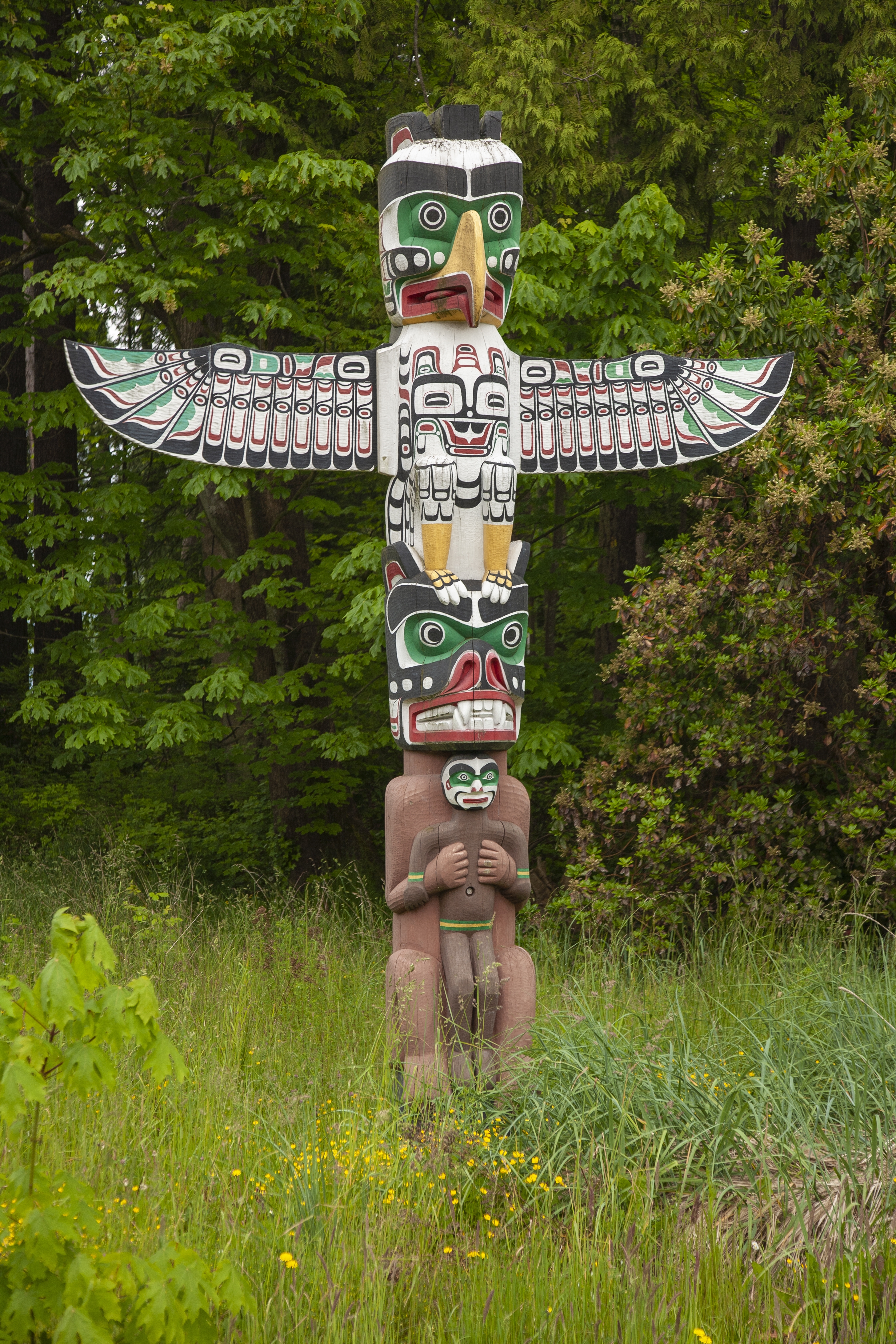A totem pole in greenery in Stanley Park near Vancouver, Canada